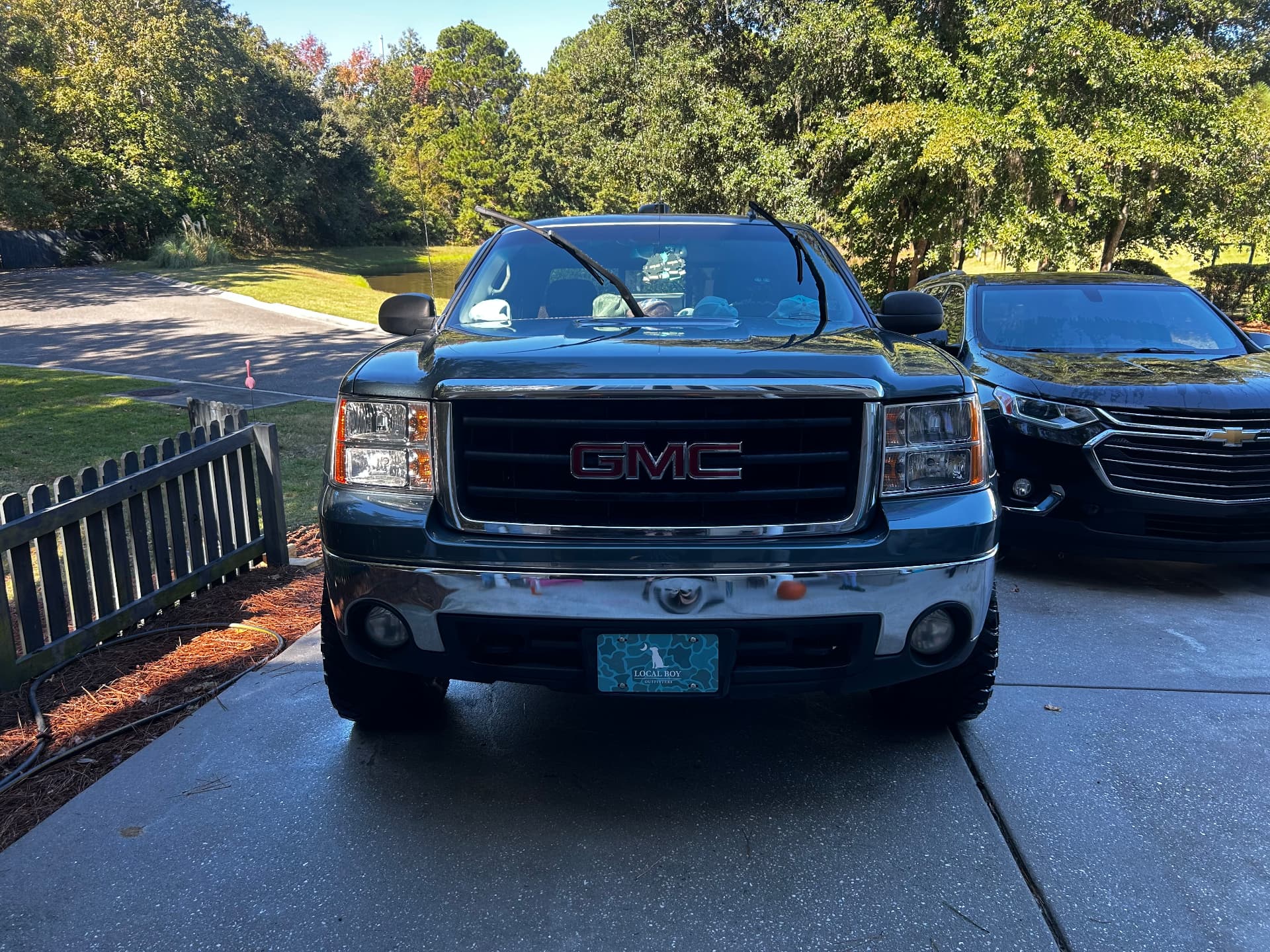 Blue GMC Sierra and black Chevrolet SUV parked together after detailing