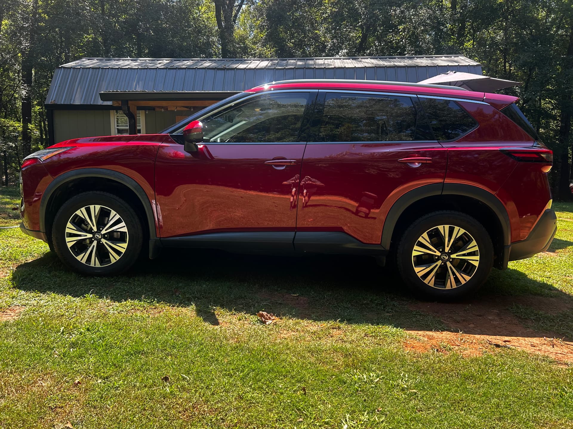 Red Nissan Rogue SUV with a deep reflective finish after detailing